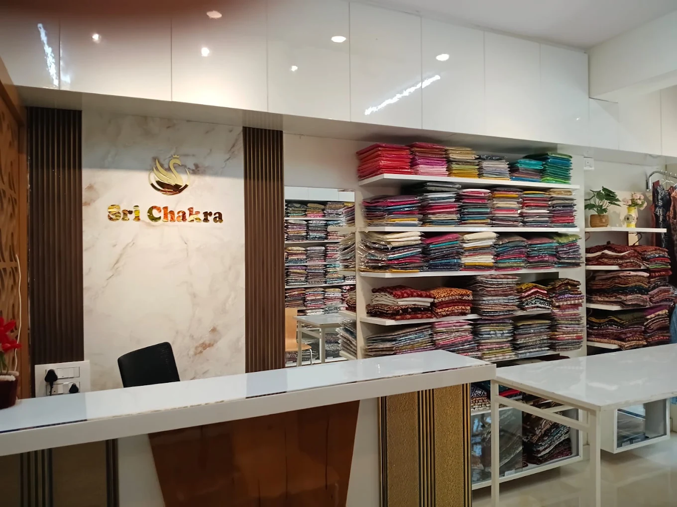 The Sri Chakra counter with the gold swan logo and shelves of folded cotton